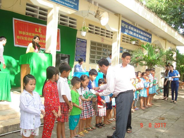 Hình 2: Ông Lê Văn Đầy - Trưởng Ban Dân vận Quận ủy Ninh Kiều trao quà cho hoc sinh xã Trung Hưng - huyện Cờ Đỏ